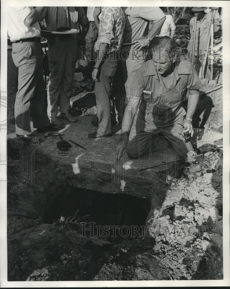 1975 Press Photo A man looking inside a sewer after an explosion - nob07253 - Historic Images