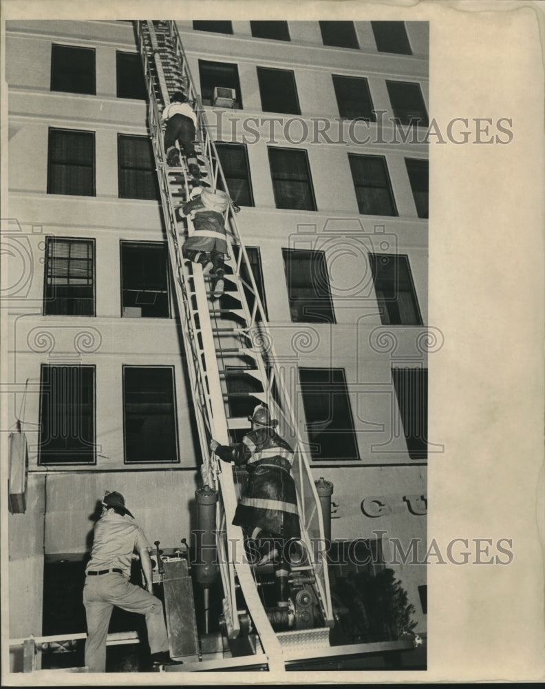 Press Photo Firefighters climbing ladder to building - Historic Images