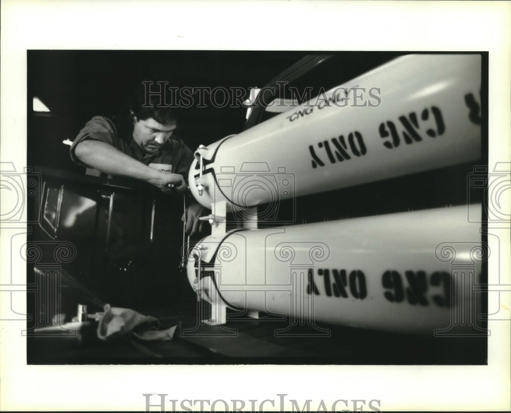1994 Press Photo Warren Simmons installs fuel line on state owned pick-up truck - Historic Images