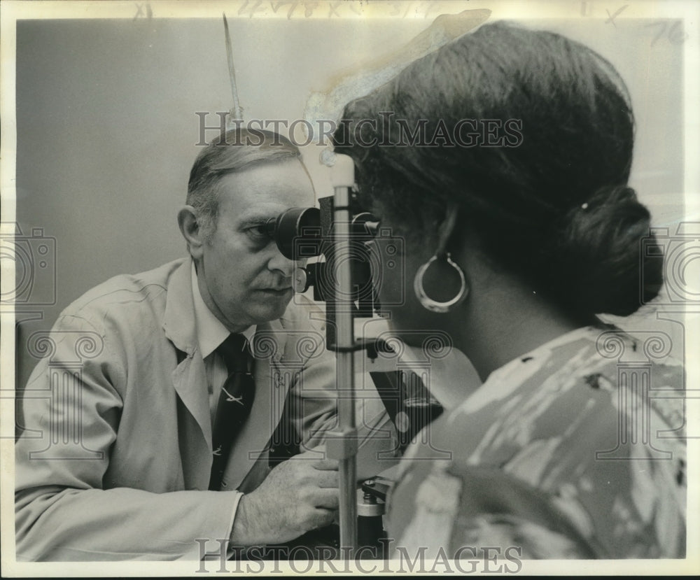 1976 Press Photo Ophthalmologist Dr. G. Porter Puryear examines eyes of patient - Historic Images