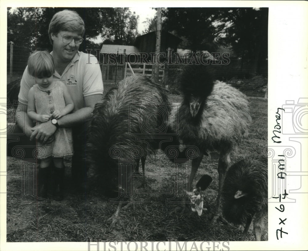 1990 Press Photo Steve Conway and daughter Carly watch Emu chicks play with keys - Historic Images