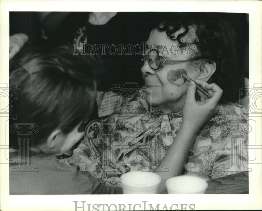 1990 Press Photo  Tiffany Walters paints heart of cheek of Hattie Turner - Historic Images