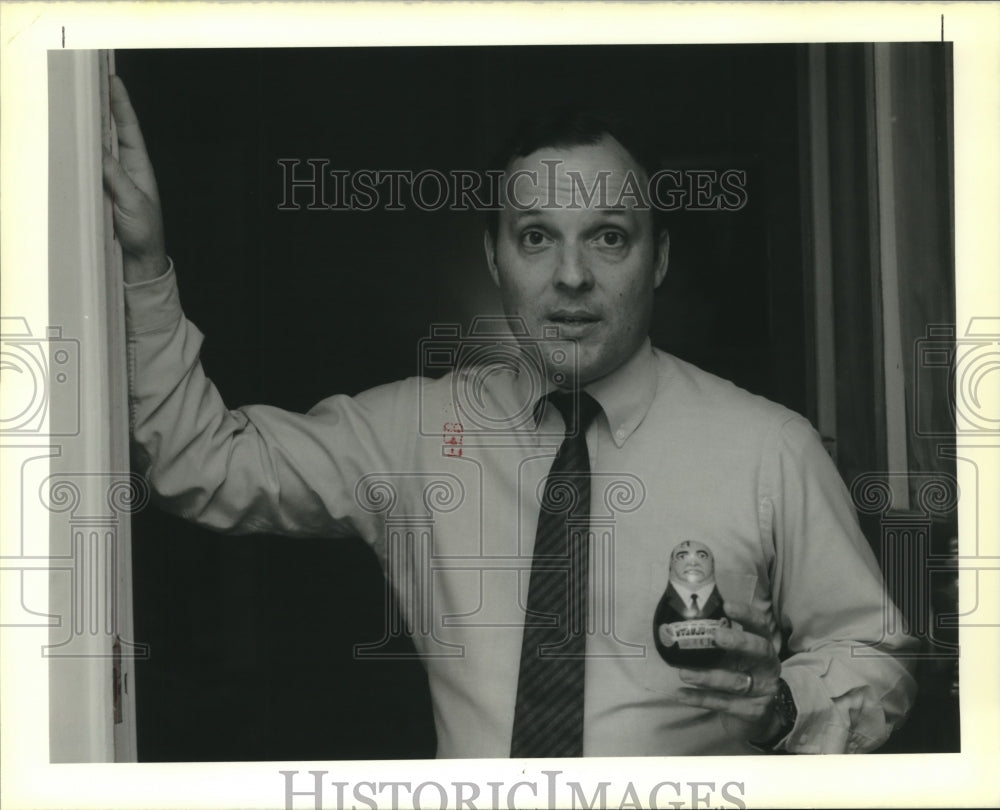 1990 Press Photo John Exnicios holds a wooden figure/doll of Mikhail Gorbachev - Historic Images