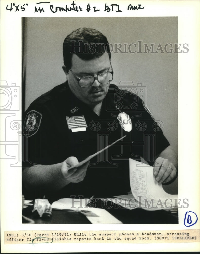 1991 Press Photo Arresting officer Tim Flynn finishes reports - Historic Images