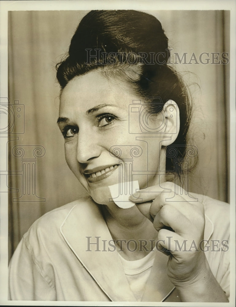 1961 Eugenia Elson holds plastic leaflet similar to two in her heart - Historic Images