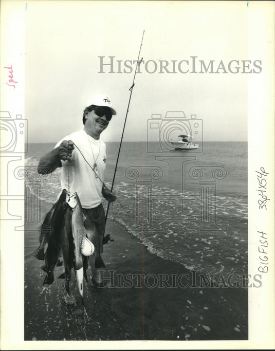 1991 Press Photo Ocean fisherman holds up his "catch of the day." - Historic Images