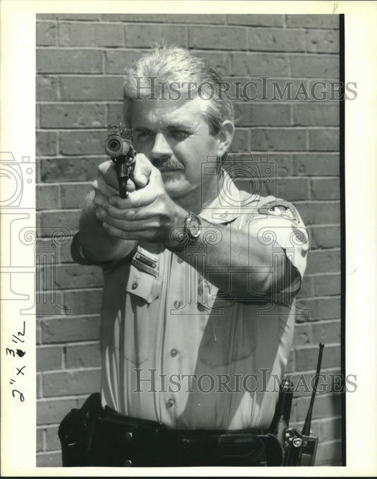 1989 Press Photo Officer Ferguson, Louisiana's "Top Gun" points his pistol - Historic Images