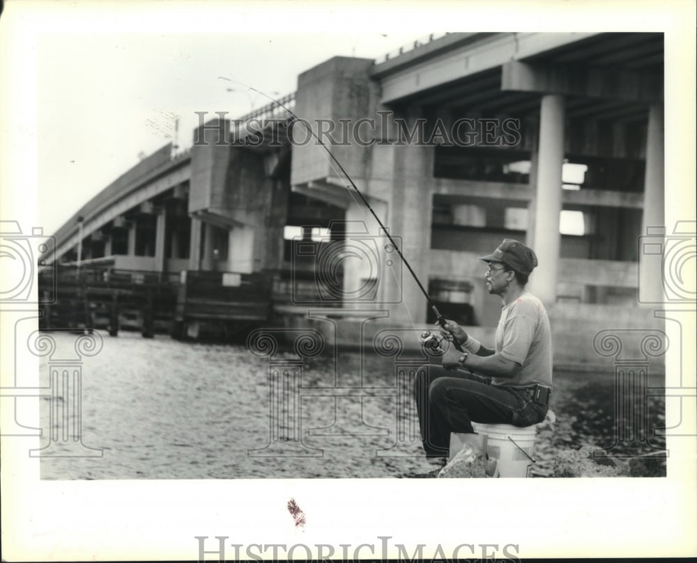 1989 Press Photo Freddie Willie fishes under Seabrook Bridge. - Historic Images