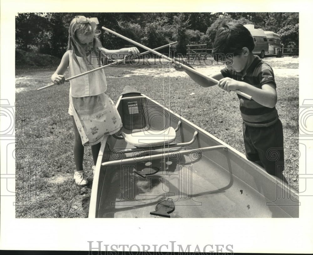 1988 Press Photo Anna Susan &amp; Timmy fish for prizes in water filled pirogue - Historic Images