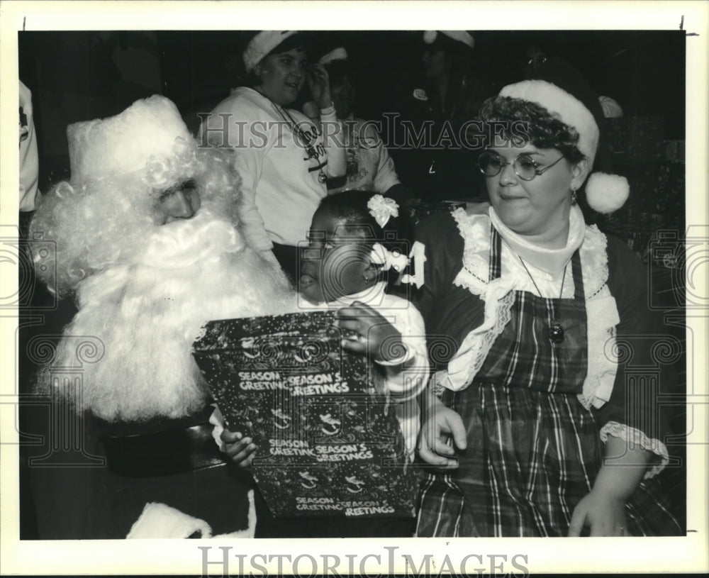 1989 Press Photo Raven Felix of New Orleans, receives a present from Santa. - Historic Images