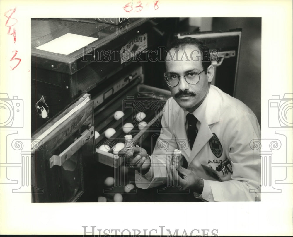 1989 Press Photo Dr. Cesar Fermin holds viles containing chicken embryos - Historic Images