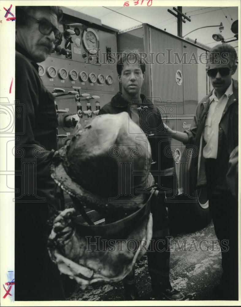 1988 Press Photo New Orleans Fire fighter Numa Jones looks at his helmet remains - Historic Images