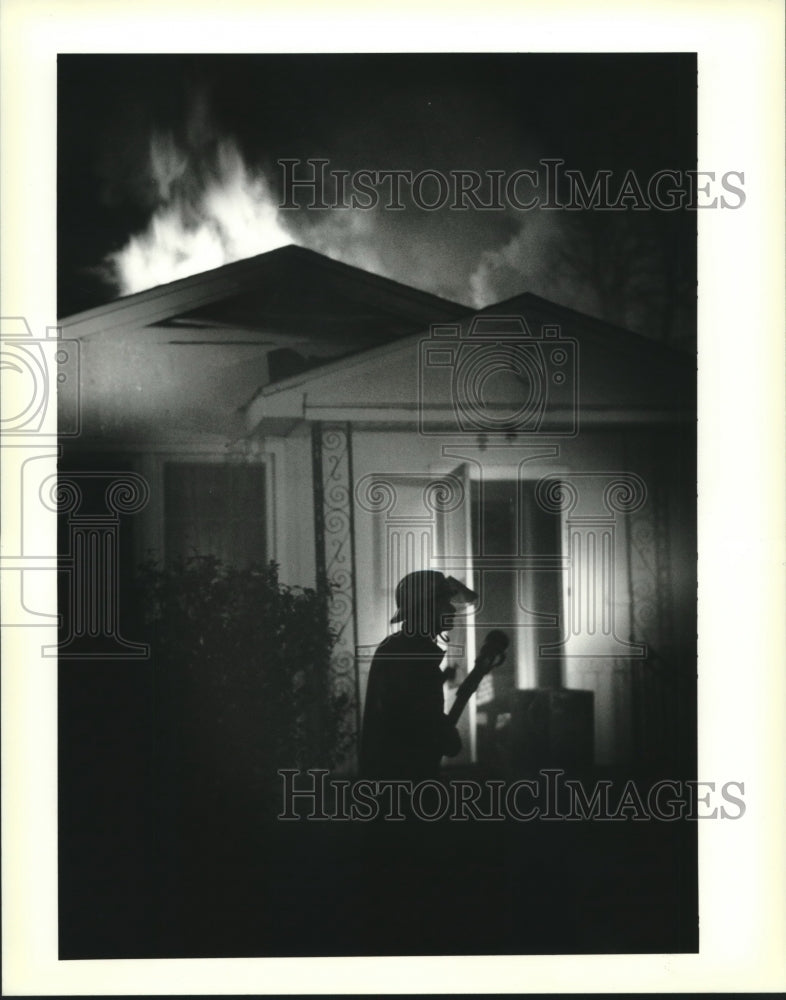 1994 Press Photo New Orleans firefighter silhouetted against a blaze in Mid-City - Historic Images