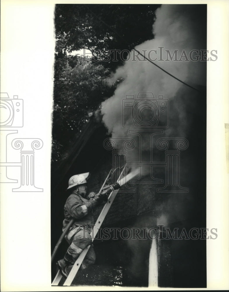 1991 Press Photo Fireman battles house fire 3820-22 Hamilton Street - Historic Images