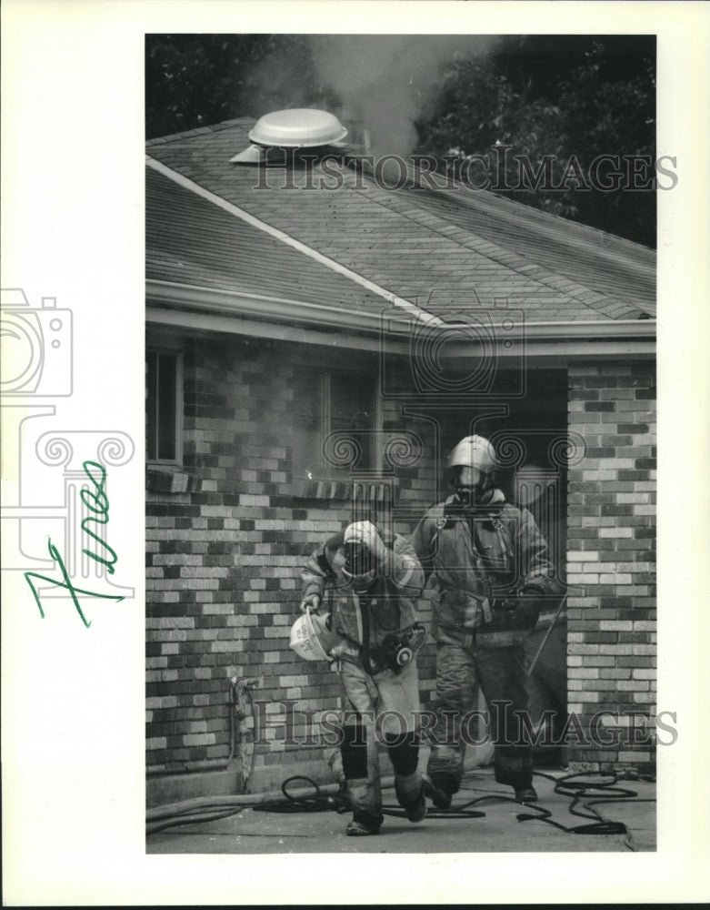 1991 Press Photo Jefferson Parish firefighters walk from smoke filled house - Historic Images