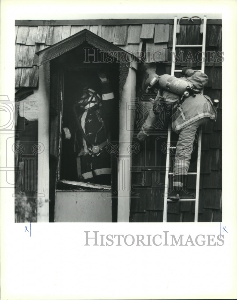 1990 Press Photo Terrytown volunteer fireman check fire damage to town-home. - Historic Images