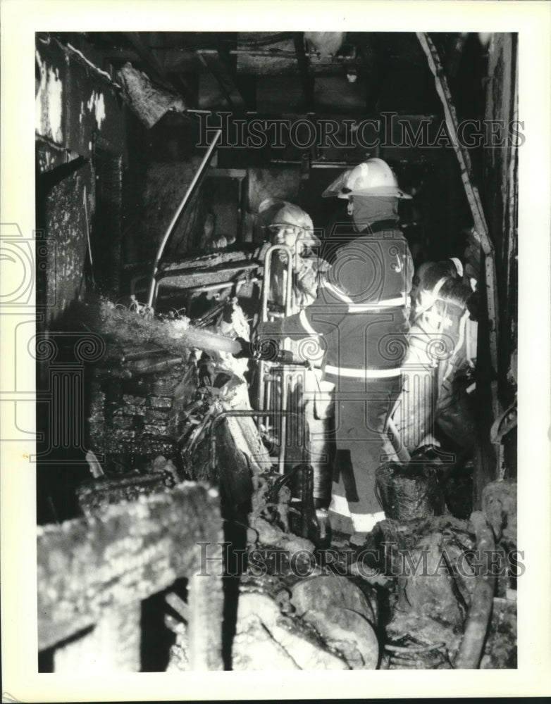 1994 Press Photo Jefferson Parish firefighters spray interior storage room wall. - Historic Images