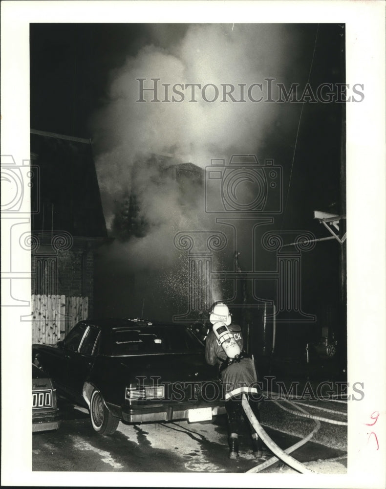 1987 Press Photo Fireman spraying the flames of an apartment fire. - nob10222 - Historic Images