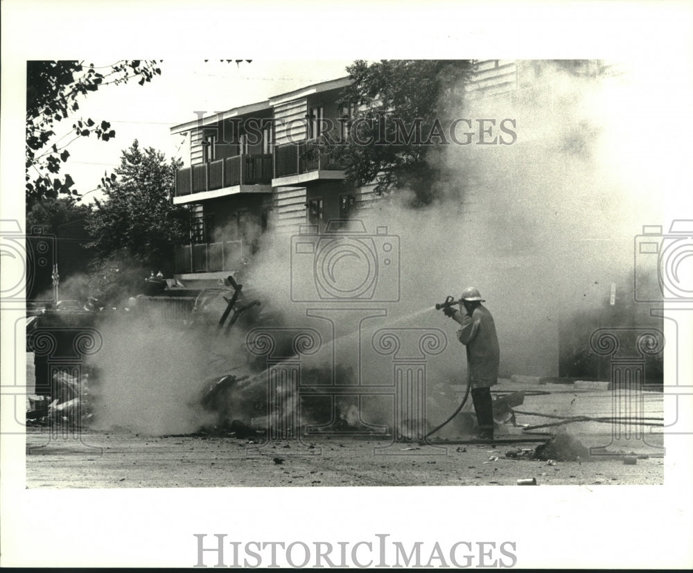 1986 Press Photo Fireman extinguishing a garbage truck fire on Interstate 10 - Historic Images