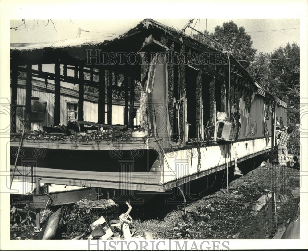 1988 Press Photo Neighbors help remove clothes from burned out trailer. - Historic Images