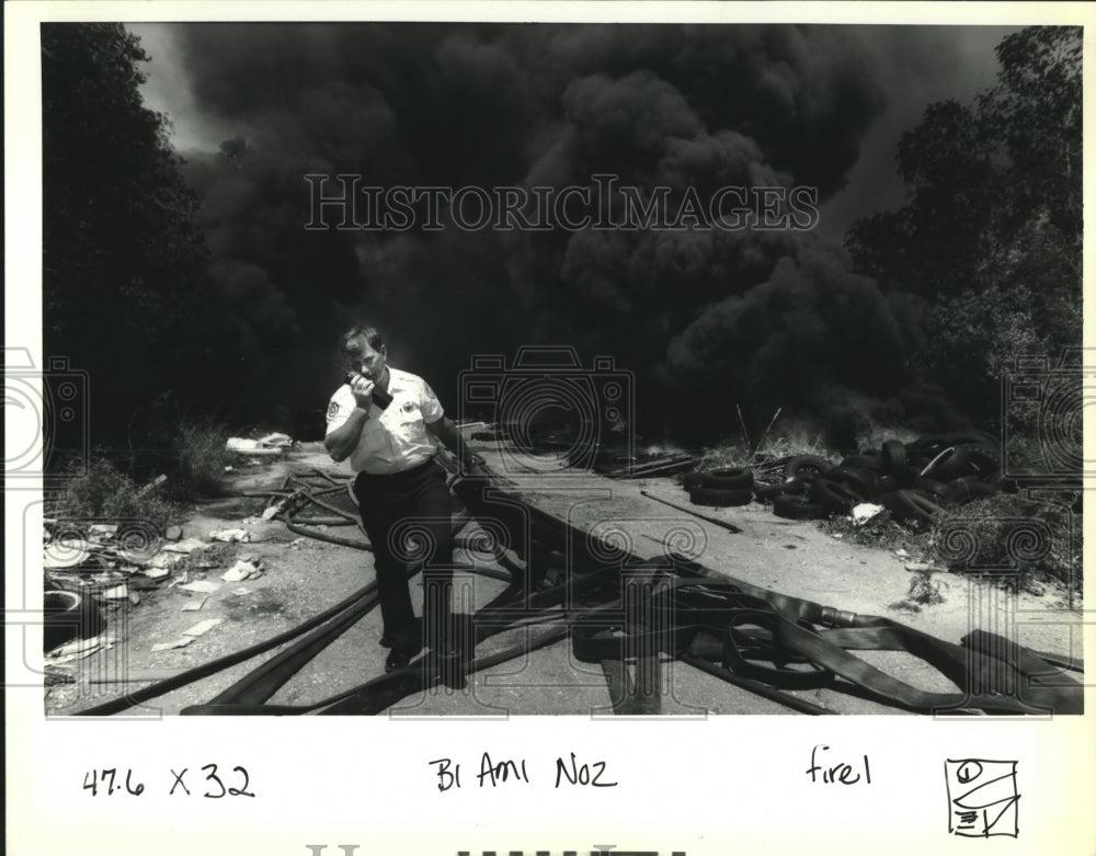 1992 Press Photo Alan Rosiere hauls back fire-hoses as he calls for back-up. - Historic Images