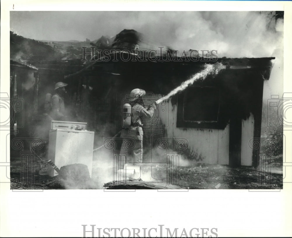 1992 Press Photo Firemen extinguish a house fire on Napoleon Street near Slidell - Historic Images