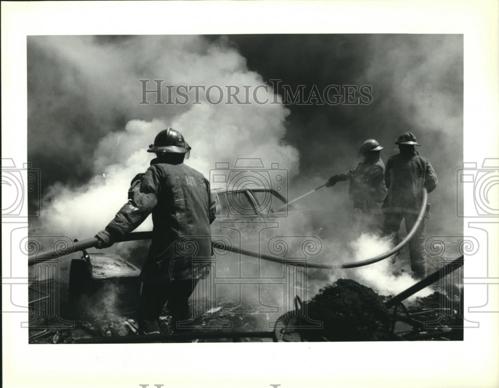 1992 Press Photo New Orleans Firemen pour water on a car on fire along I-10 - Historic Images