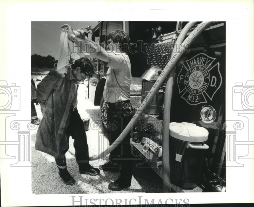 1990 Press Photo West Jefferson EMT drapes cold towel around Marrero fireman. - Historic Images