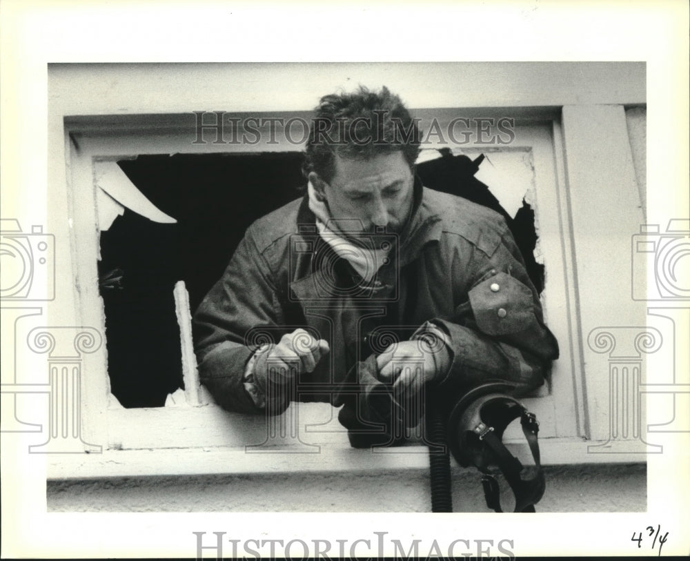 1990 Press Photo Firefighter Joe Dullery sticks head form attic window. - Historic Images