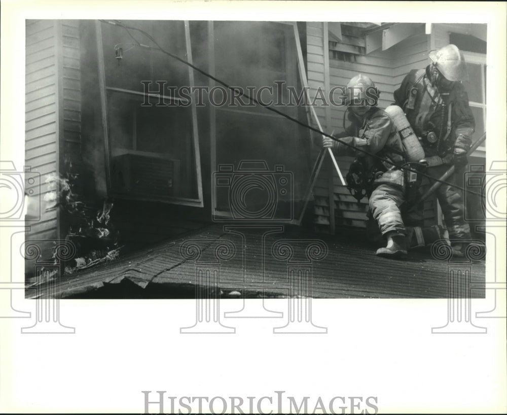 1991 Press Photo Firefighters prepare to enter upstairs window of house fire. - Historic Images