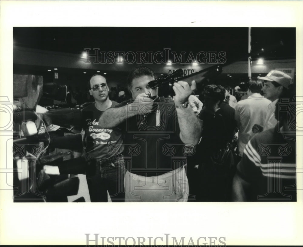 1990 Press Photo Jack Serio checks out 30/06 rifle at St. Bernard gun show. - Historic Images