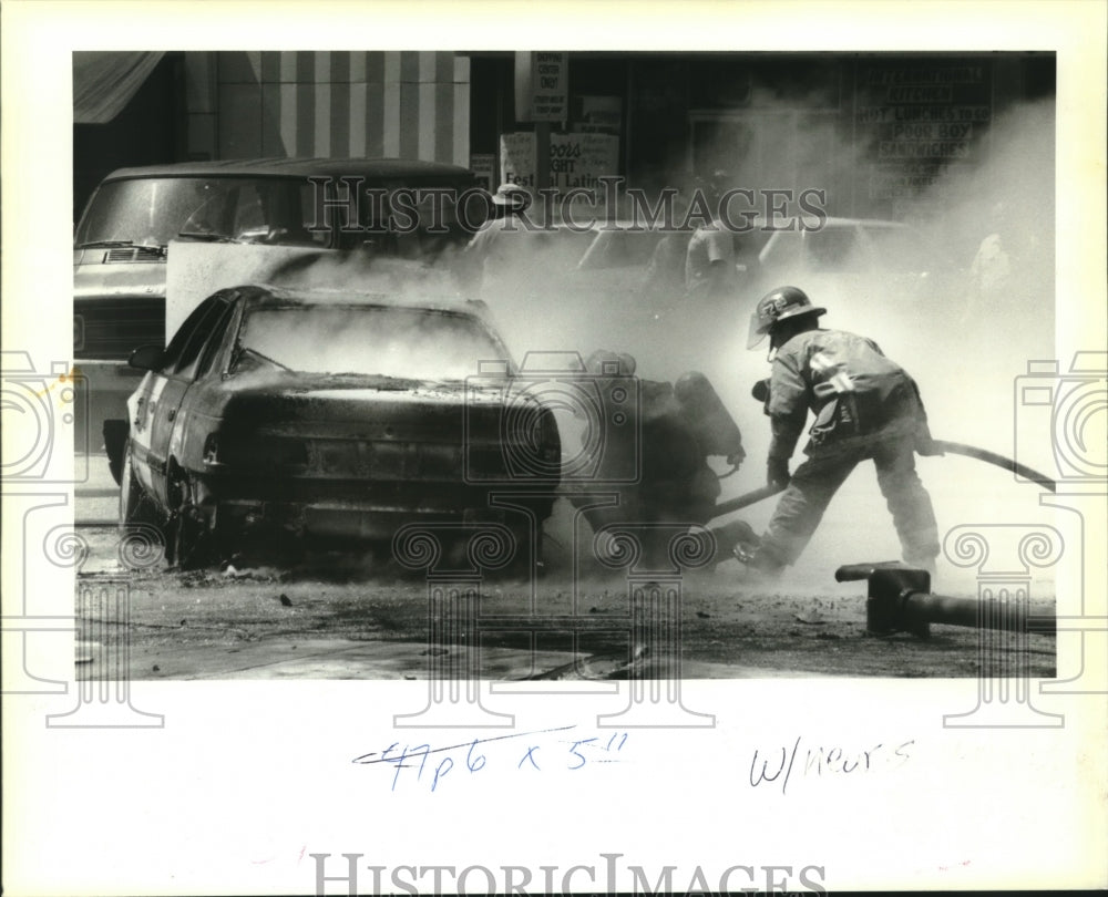 1994 Press Photo New Orleans Firefighters put out a fire in a Ford Taurus - Historic Images