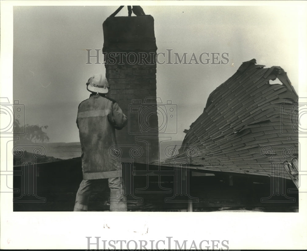 1986 Press Photo Firefighter Greg Parr surveys fire damage of house in Metairie - Historic Images