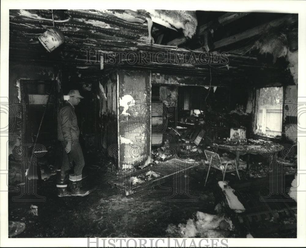 1987 Press Photo Terrytown fireman looks at fire-damaged house of Ronald Johnson - Historic Images