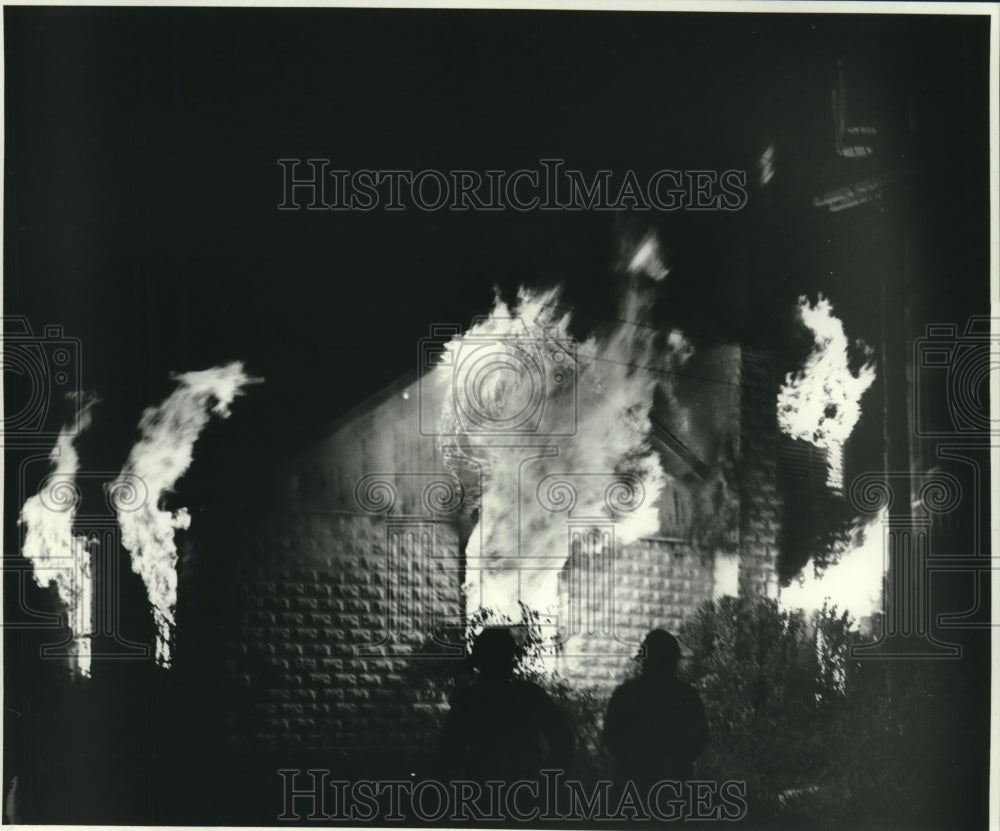 1987 Press Photo Firefighters try to fight a growing fire at one of the houses - Historic Images