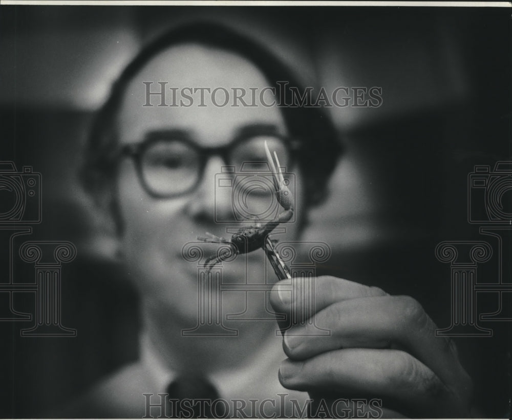 Press Photo A man holding a tiny fiddler crab - nob11126 - Historic Images