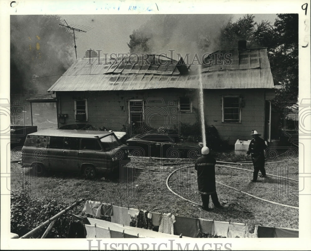 1981 Press Photo Fireman hoses down the roof of a one-story house - nob11196 - Historic Images