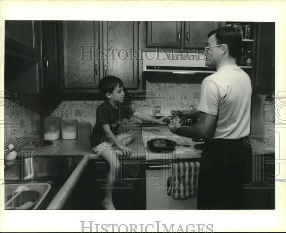 1990 Press Photo T.J. Fisla helps his father Tom cook supper for them - Historic Images