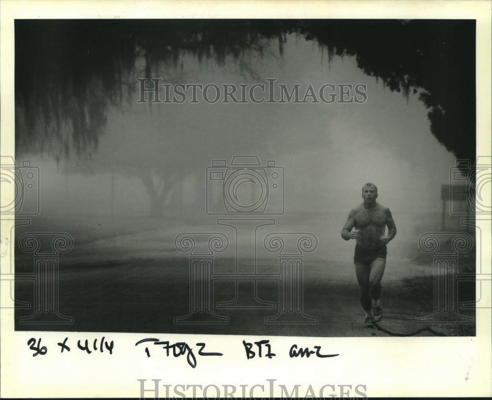 1989 Press Photo Phillip Nichols jogs along the fog on Lakeshore Drive - Historic Images