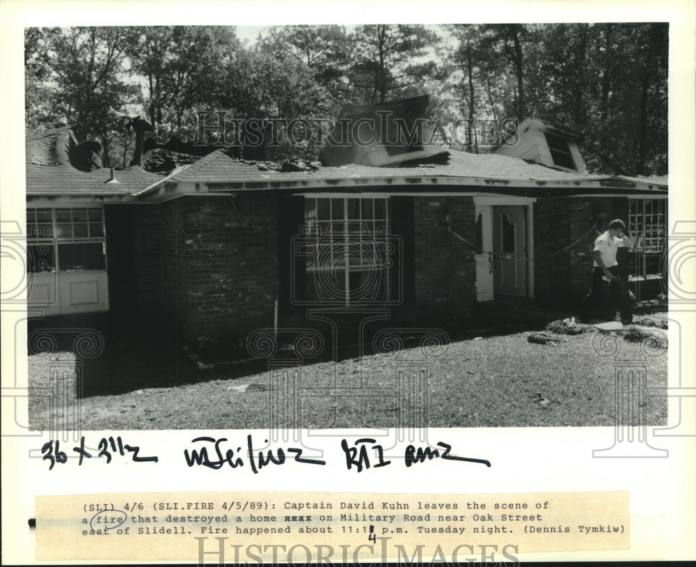 1989 Press Photo Captain David Kuhn leaves house destroyed by fire on Military - Historic Images