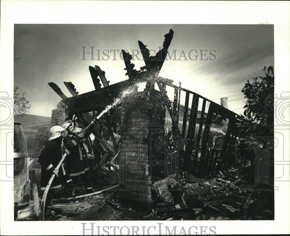 1986 Press Photo Kenner firefighters finishing up at 85 Kilgore St. house fire - Historic Images