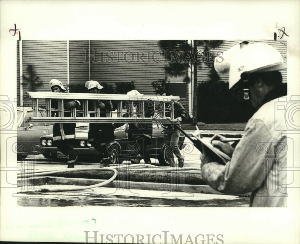 1988 Press Photo Firemen carry ladder to get to third floor apartment fire - Historic Images