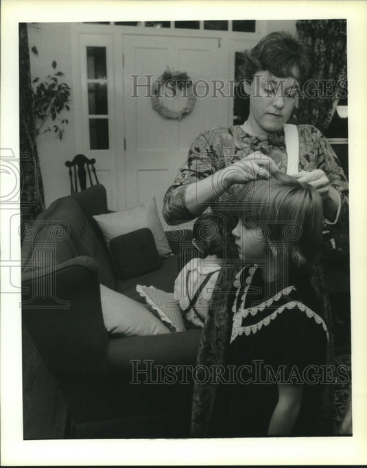 1989 Press Photo Cherie Fouquet fixes her daughter hair for Christmas night out - Historic Images