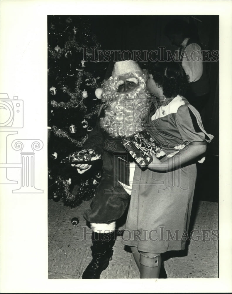 1984 Press Photo Desiree La Bauve kisses Santa at Fradella Hospitality House - Historic Images