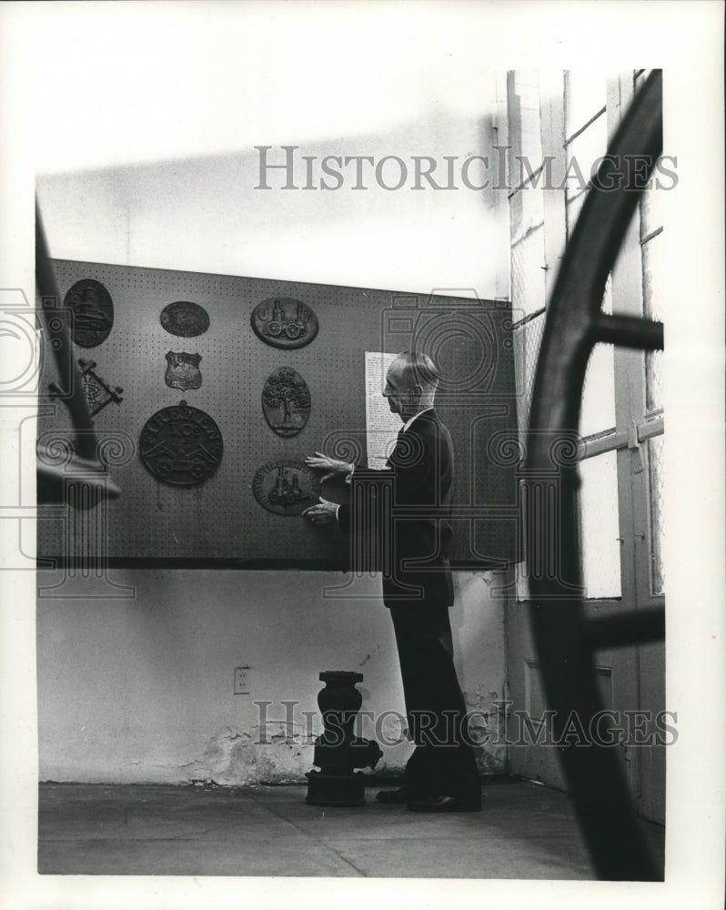 1963 C.E. Frompton of Louisiana State Museum straightens an artwork - Historic Images