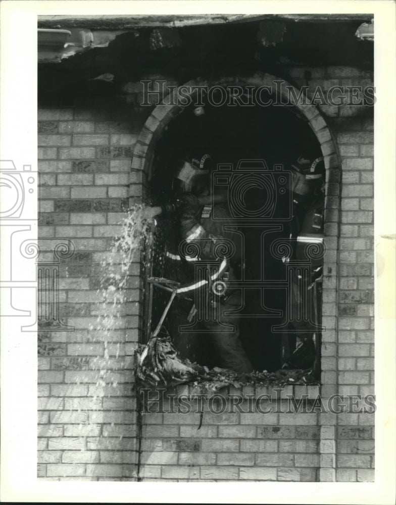 1992 Press Photo Fireman pours water on bricks to cool them off. - Historic Images