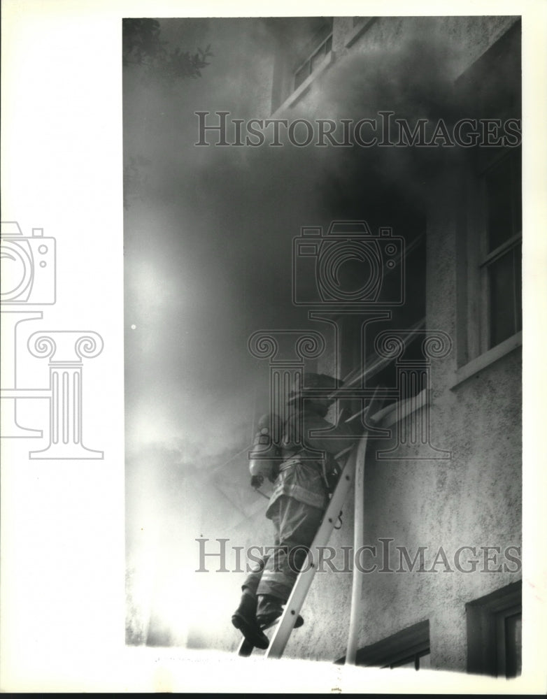 1992 Press Photo New Orleans firefighter fights a fire at Eleanor McMain School - Historic Images