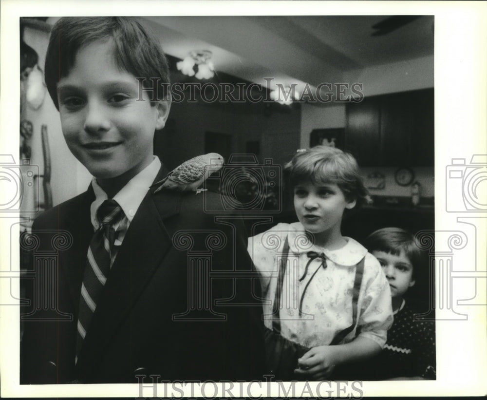 1989 Press Photo Bobby Fouquet shows the family parakeet to Darlene and Megan - Historic Images