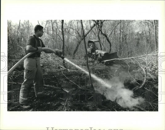 1994 Press Photo Firefighter Clinton Young sprays water into underground fire. - Historic Images