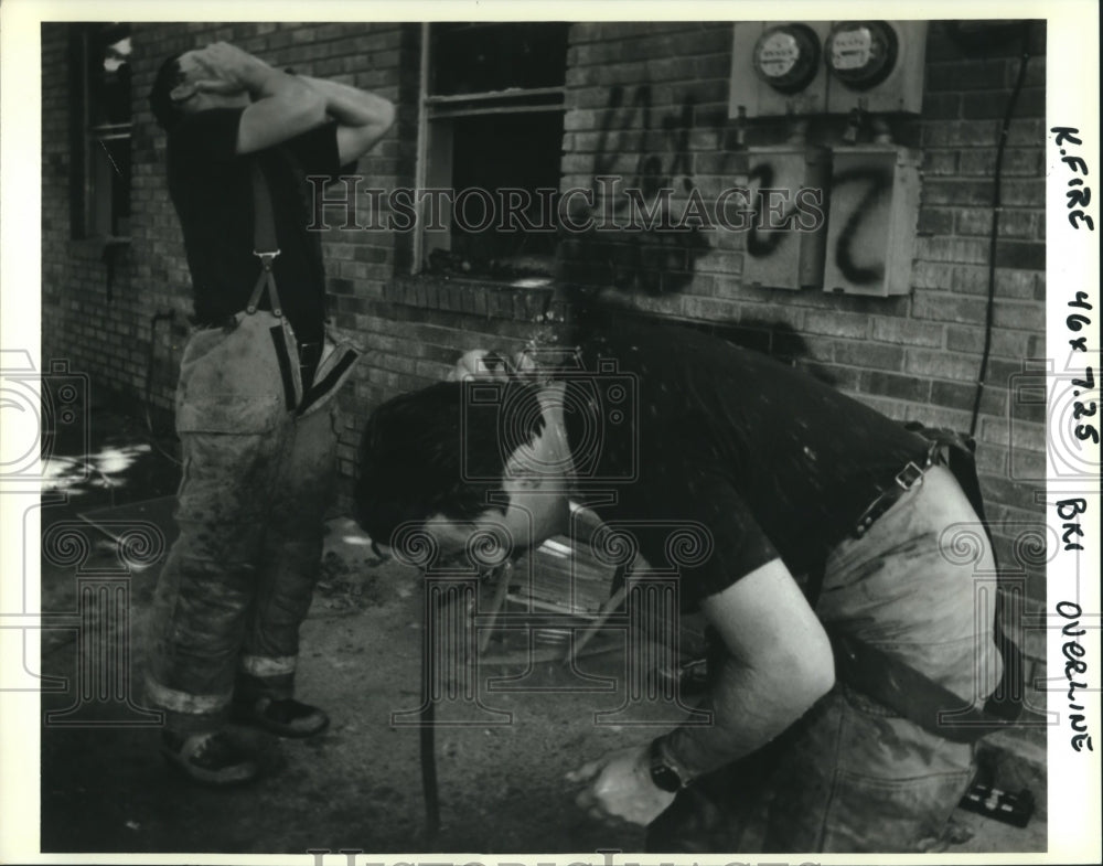 1993 Press Photo Kenner firefighters cool off with garden hose at 2-alarm fire. - Historic Images